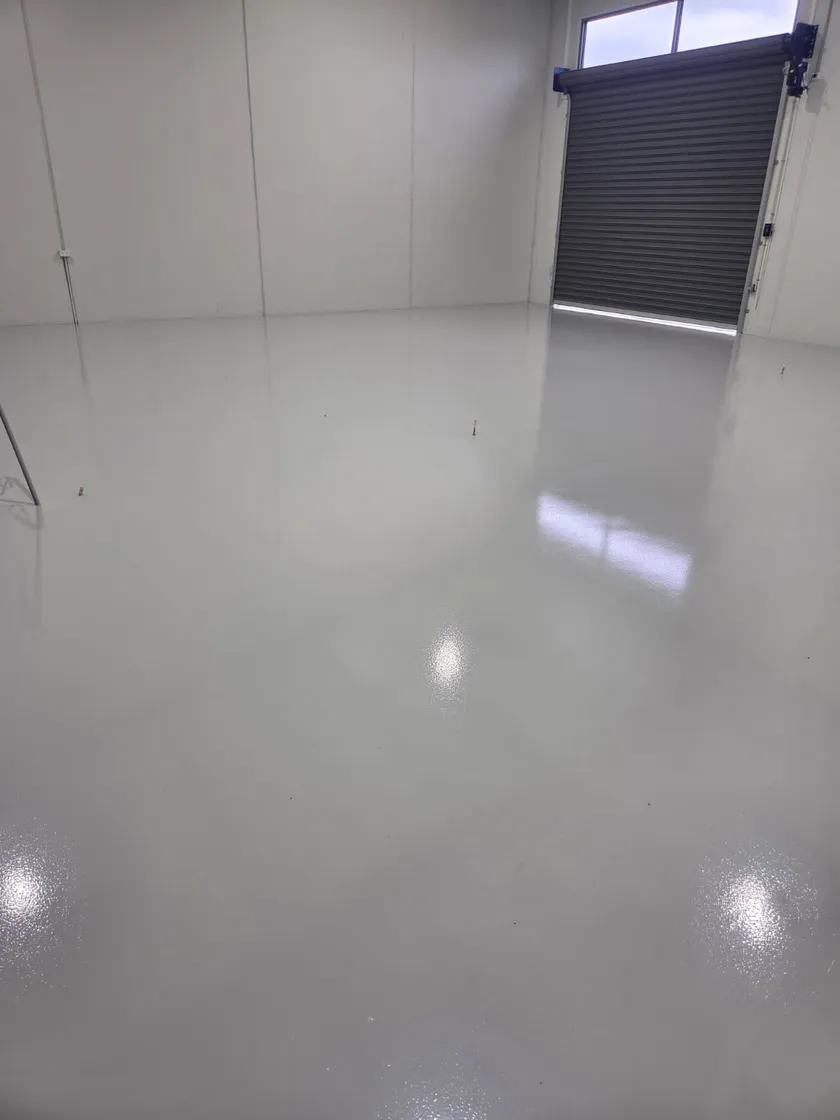 Glossy light-grey commercial epoxy floor in an empty unit