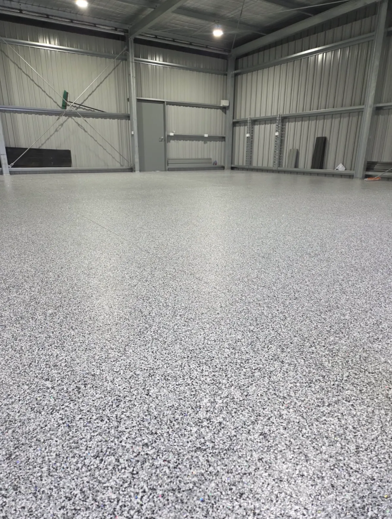 Charcoal flake epoxy floor in a warehouse, full view and close-up