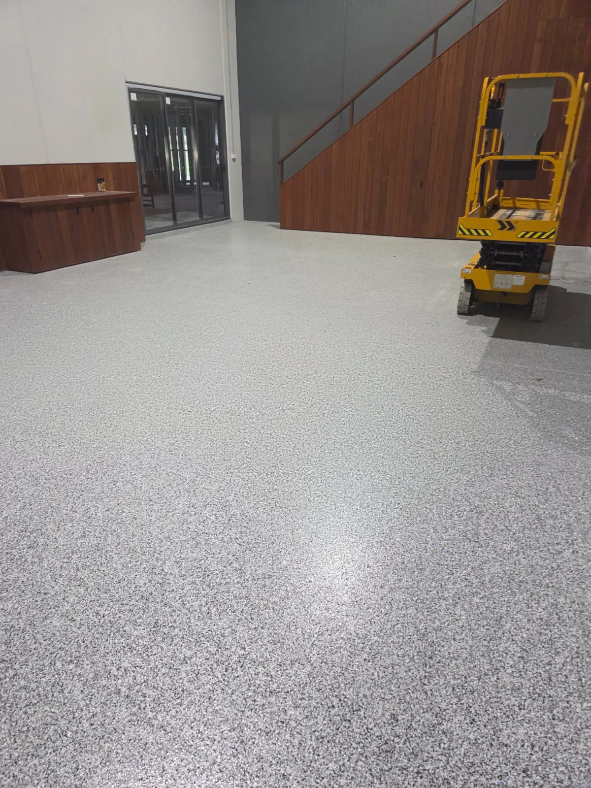 Grey flake epoxy floor in a commercial fitout with timber staircase