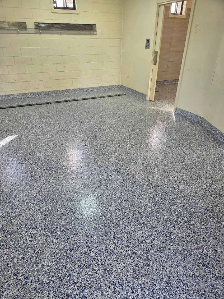 Blue-grey flake epoxy floor in a bathroom and amenities area