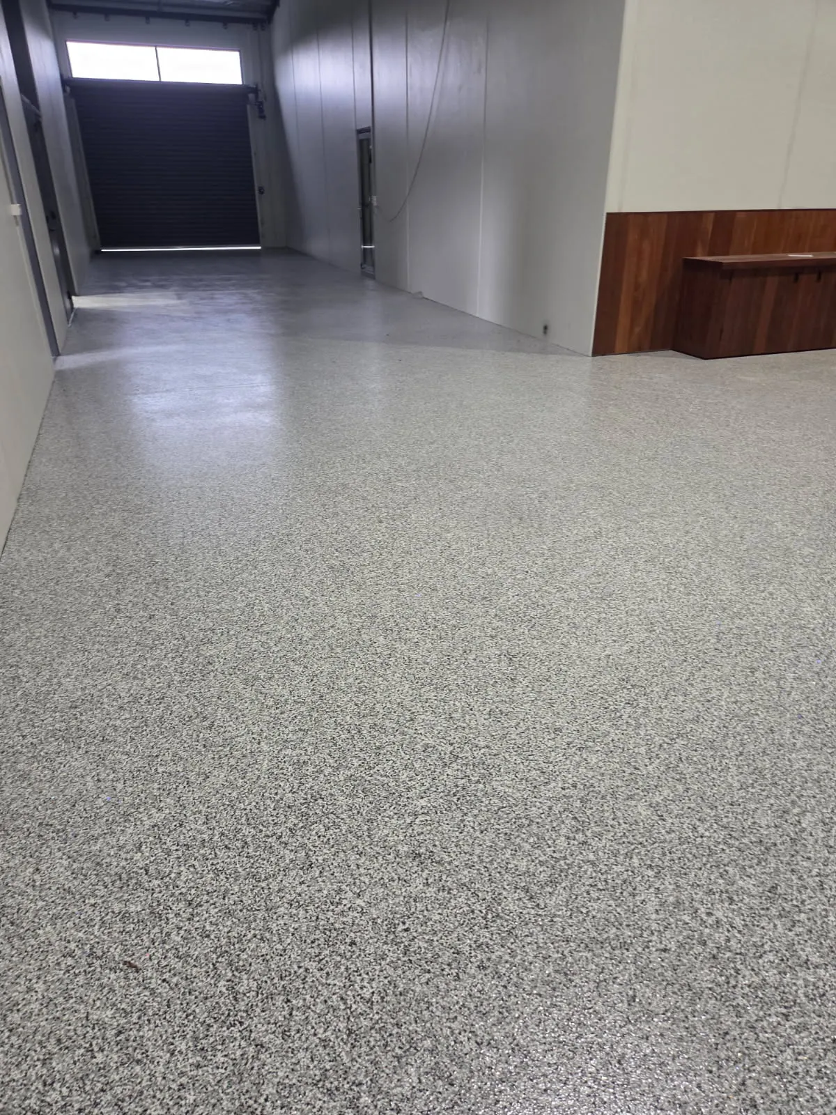 Grey flake epoxy floor in a warehouse corridor