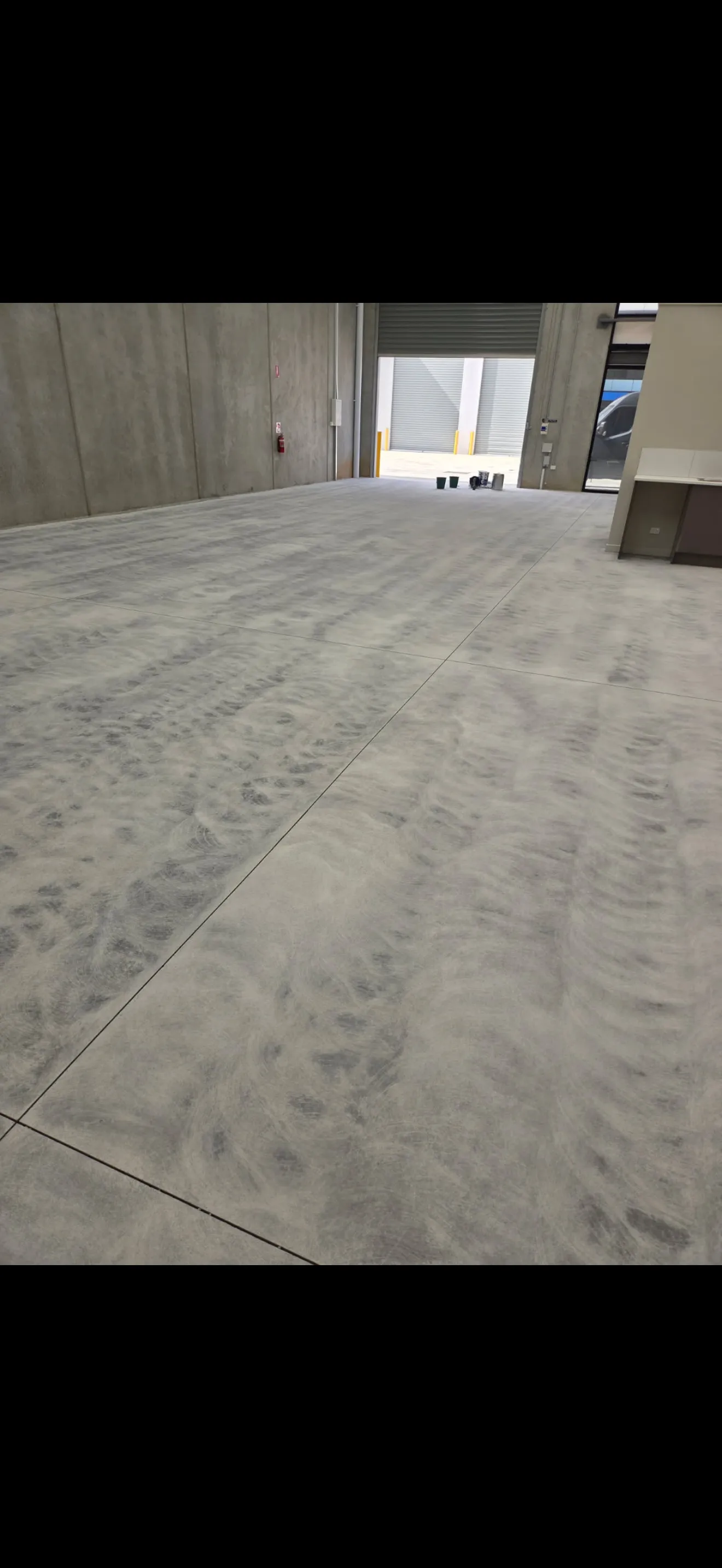 Raw concrete floor before coating at a warehouse loading dock